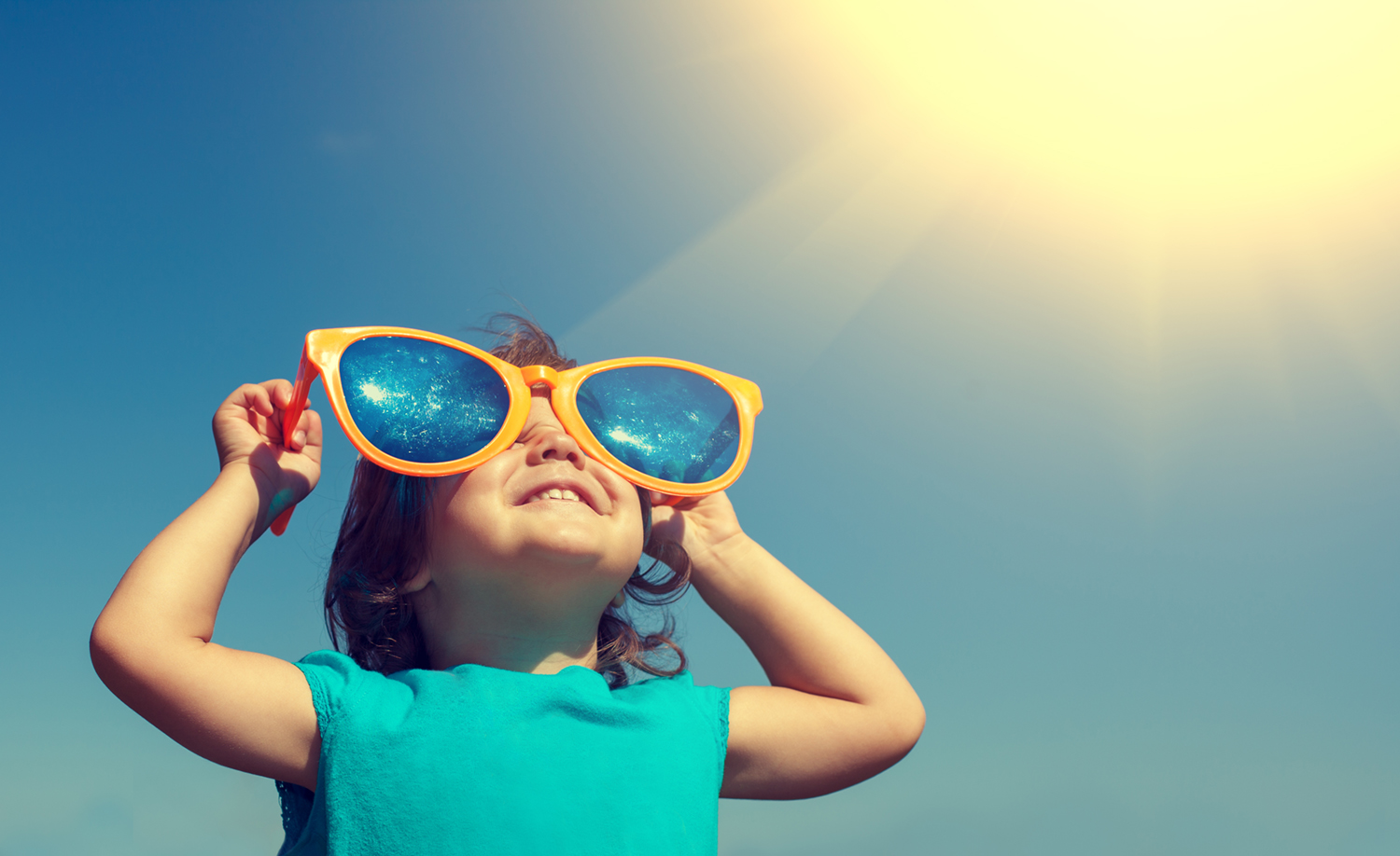 Happy,Little,Girl,With,Big,Sunglasses,Looking,At,The,Sun